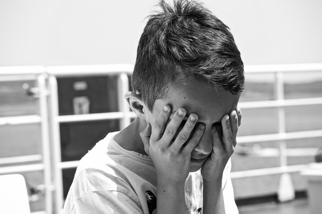 両手で両目を隠している男の子の画像