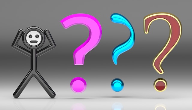 クエスチョンマークの群れの前に立っている人